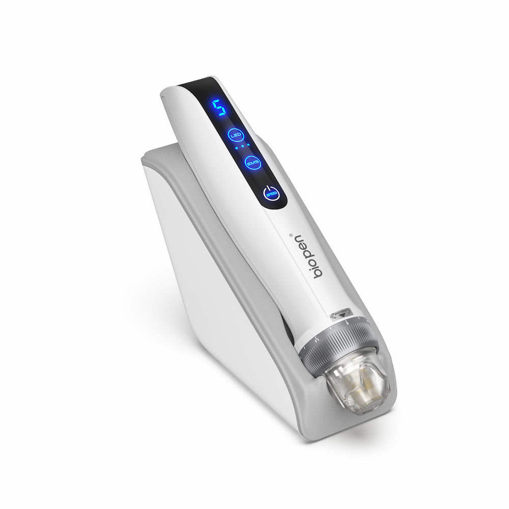 Bolígrafo BioPen blanco Q2 microneedling colocado en un soporte gris, con pantalla LED azul y módulo de aguja transparente al frente.