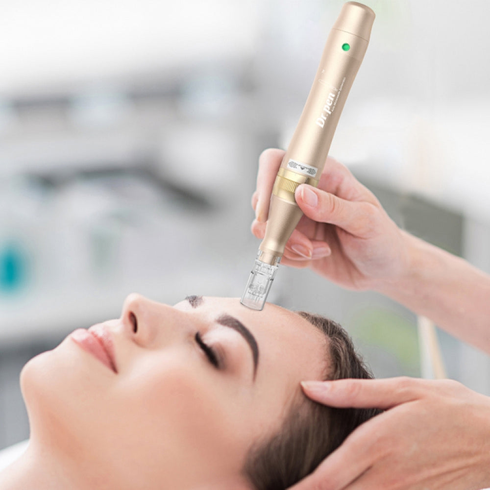 Una persona está relajada mientras un terapeuta realiza microneedling en la frente con un Dr. Pen M5 de color dorado. El terapeuta sostiene el lápiz con ambas manos para mayor precisión.