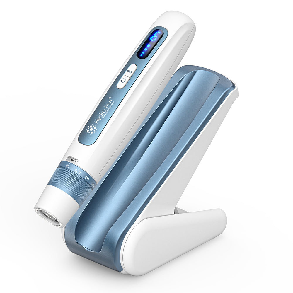 HydraPen H5 pluma blanca y azul microneedling colocada en su base de carga, dispositivo de microagujas avanzado para infusión de suero eficaz y rejuvenecimiento de la piel.