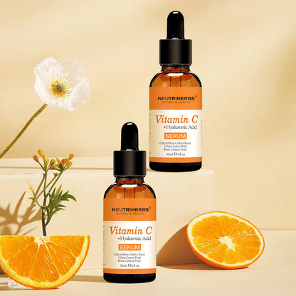 Neutriherbs Vitamin C + Hyaluronic Acid Serum 30 ml junto a naranjas frescas y flores. Imagen inspiradora del producto que destaca el contenido de vitamina C del sérum para una piel hidratada, mayor luminosidad y un tono de piel más uniforme.